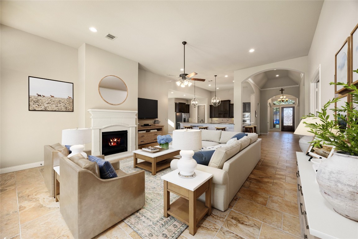 23211 Ruspino Shores Place Katy, TX 77493 - Photo 16 of 39 a living room with furniture a fireplace and a chandelier
