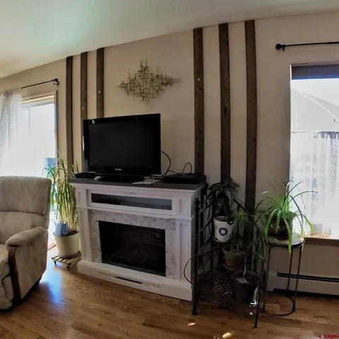 a living room with furniture a fireplace and potted plants
