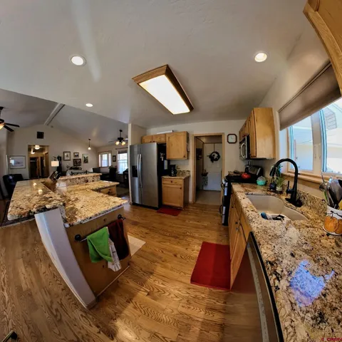 a large kitchen with kitchen island a stove a sink dishwasher and a dining table with granite countertop