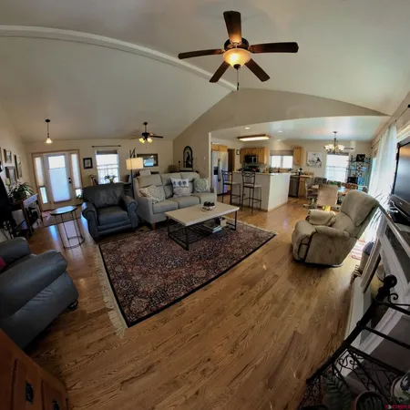 a view of a dining room with furniture a chandelier and wooden floor