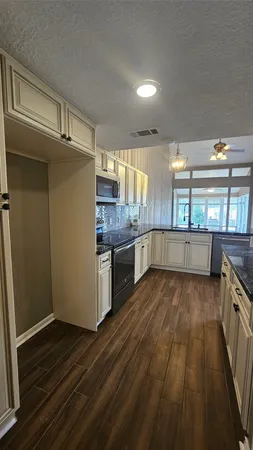 a kitchen with stainless steel appliances wooden floors and wooden cabinets