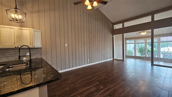 a view of a livingroom with wooden floor and furniture