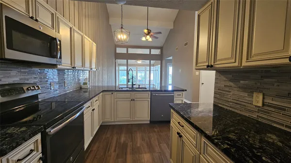 a kitchen with a sink stove and microwave