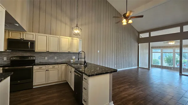 a kitchen with stainless steel appliances granite countertop a sink and microwave