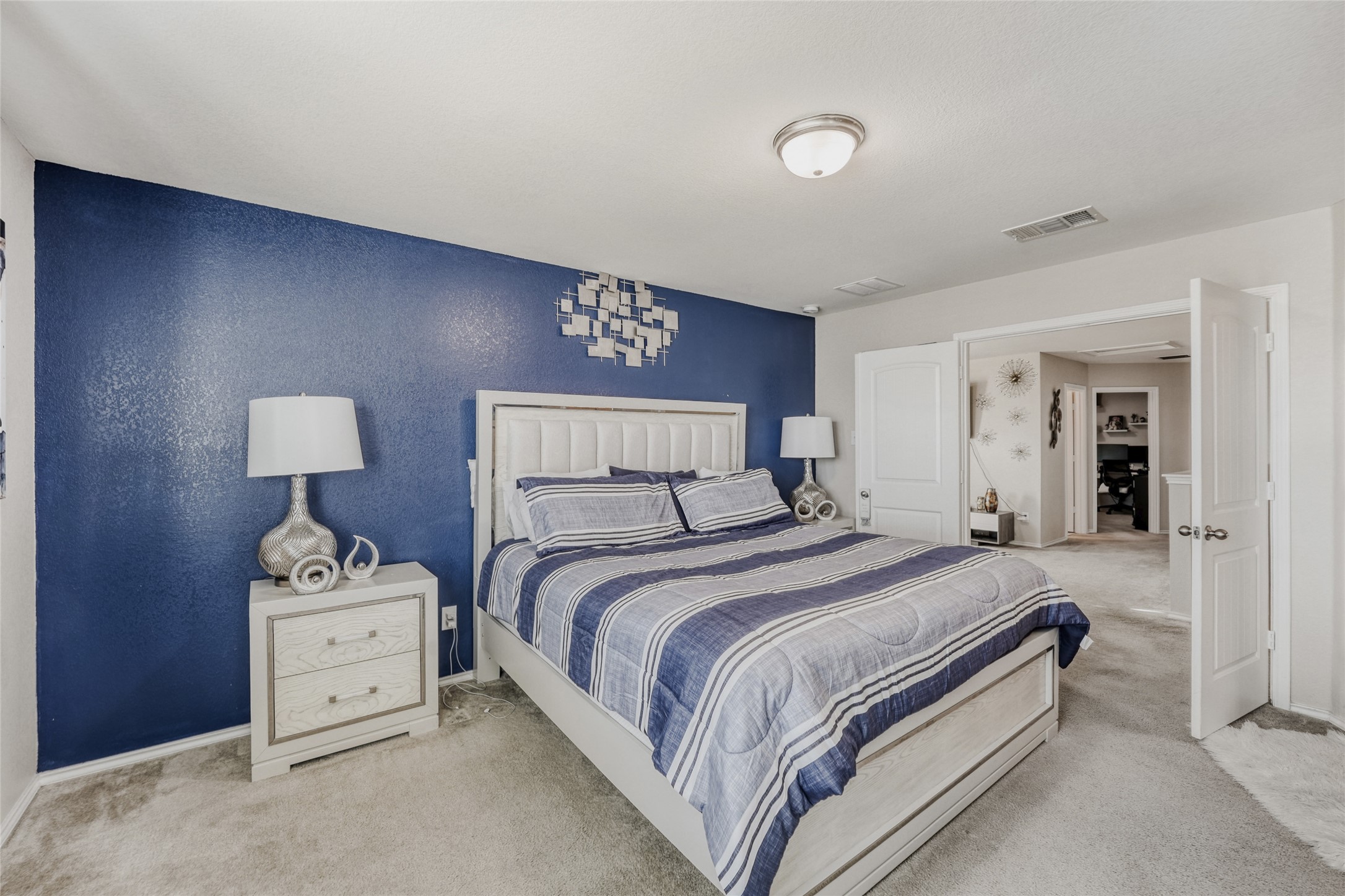 13604 Vigilance Street Manor, TX 78653 - Photo 14 of 28 a bedroom with a bed and a lamp on table