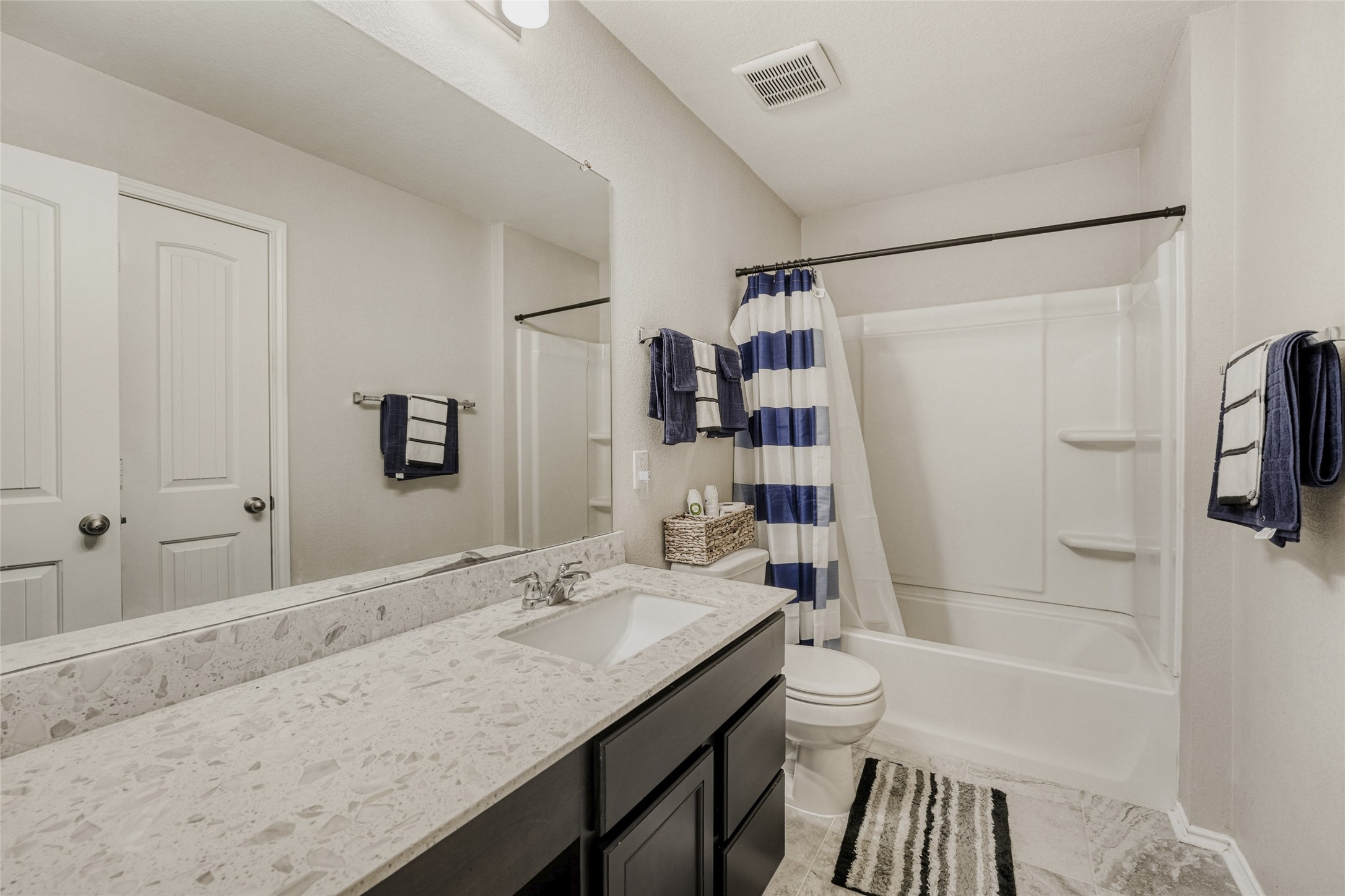 13604 Vigilance Street Manor, TX 78653 - Photo 23 of 28 a bathroom with a granite countertop sink a toilet and shower
