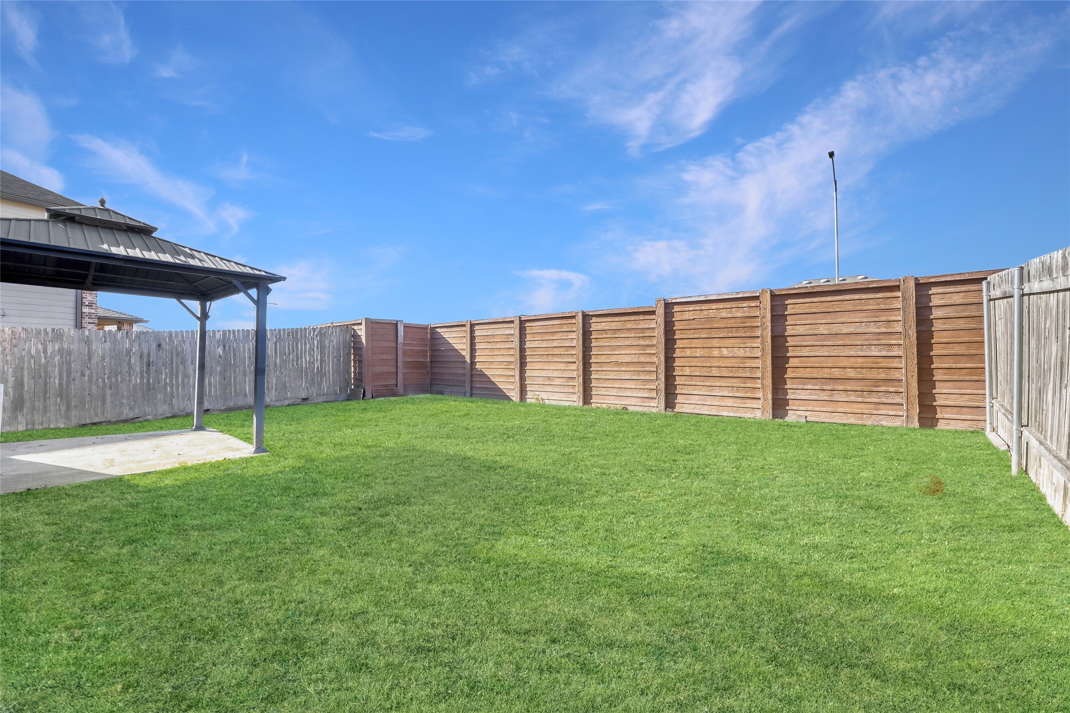 13604 Vigilance Street Manor, TX 78653 - Photo 28 of 28 a view of a backyard with a barbeque grill and wooden fence