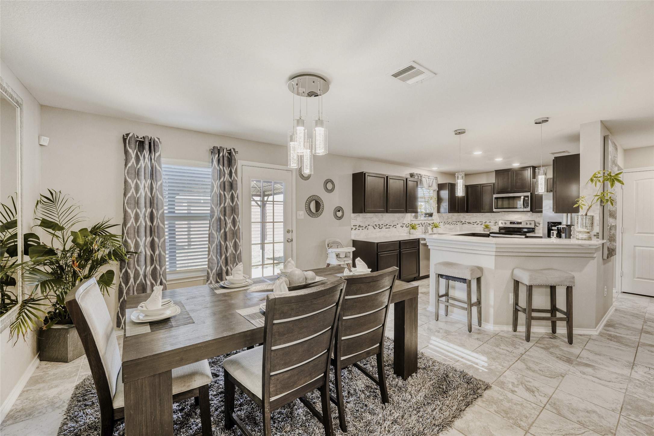 13604 Vigilance Street Manor, TX 78653 - Photo 6 of 28 a kitchen with a table chairs stove and cabinets