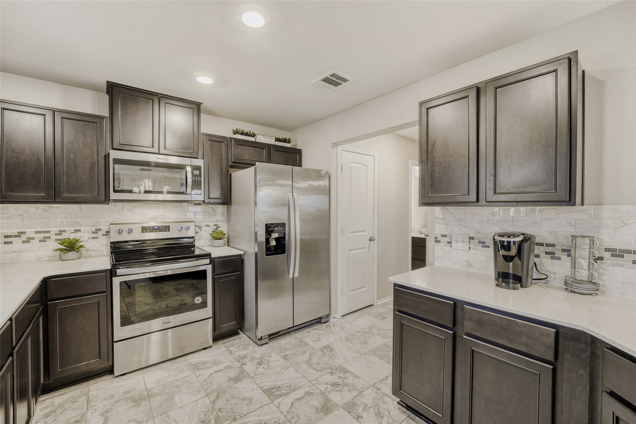 13604 Vigilance Street Manor, TX 78653 - Photo 7 of 28 a kitchen with stainless steel appliances granite countertop a refrigerator stove and sink