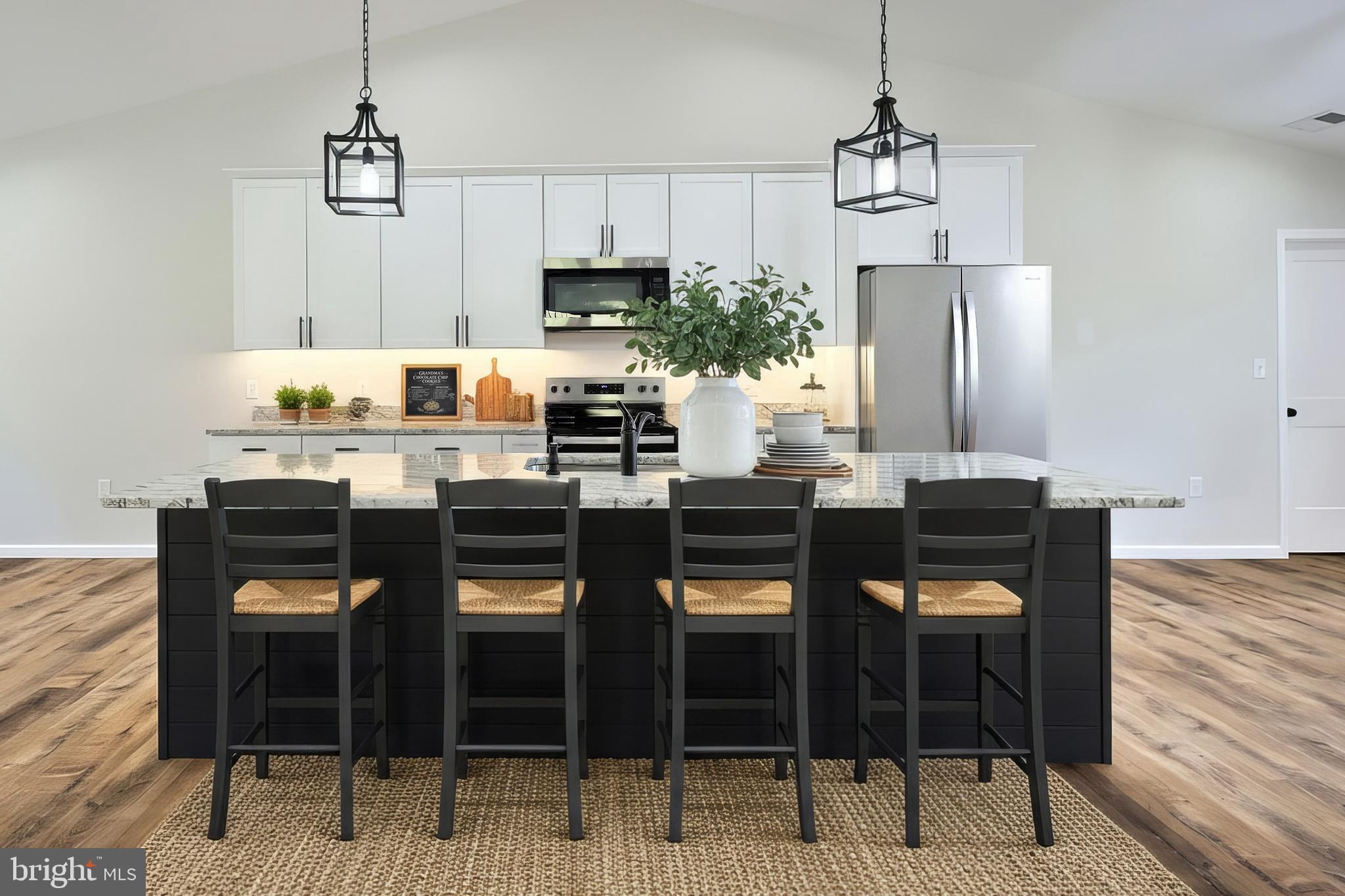 10640 Enfield Road Felton, PA 17322 - Photo 16 of 59 a kitchen with granite countertop a table chairs stove and white cabinets