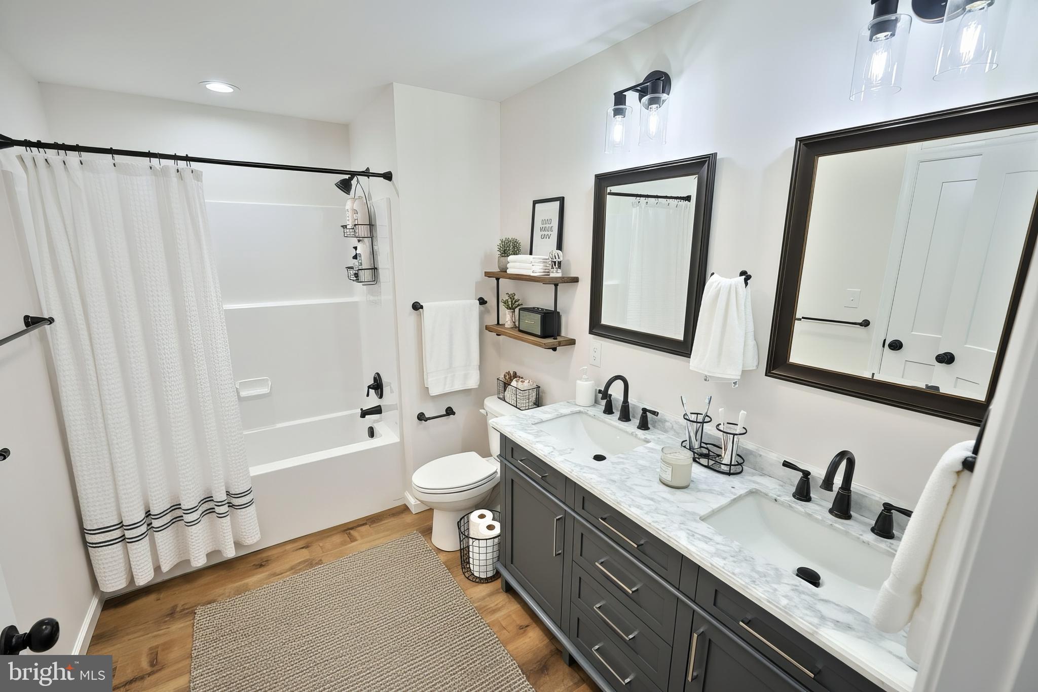 10640 Enfield Road Felton, PA 17322 - Photo 21 of 59 a bathroom with a double vanity sink toilet mirror and shower