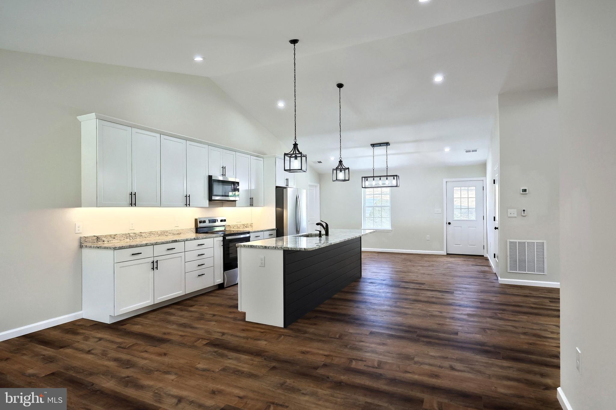 10640 Enfield Road Felton, PA 17322 - Photo 32 of 59 a large kitchen with kitchen island a sink stainless steel appliances and cabinets