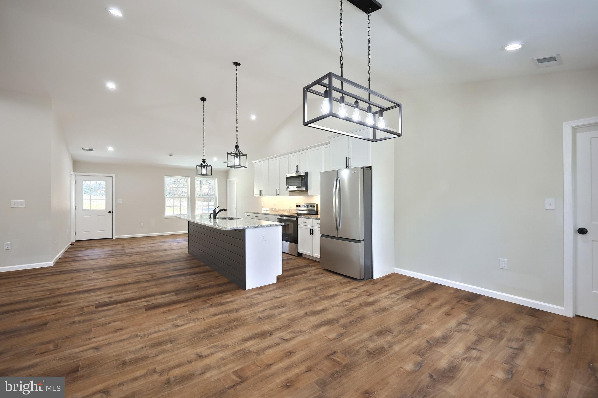 10640 Enfield Road Felton, PA 17322 - Photo 34 of 59 a kitchen with stainless steel appliances kitchen island a refrigerator and a wooden floor