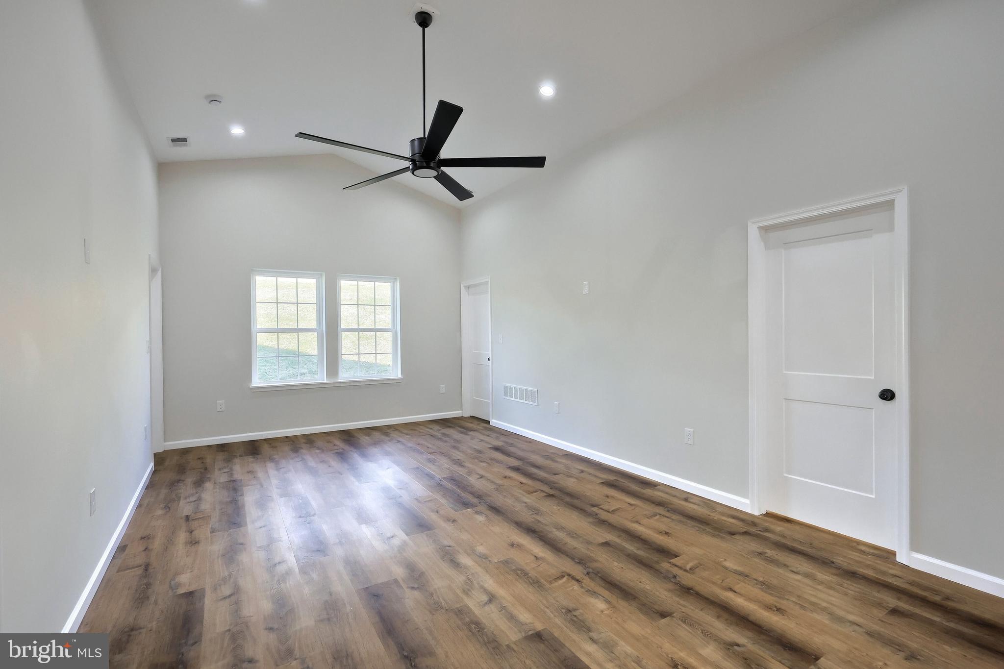 10640 Enfield Road Felton, PA 17322 - Photo 43 of 59 an empty room with wooden floor a ceiling fan and windows