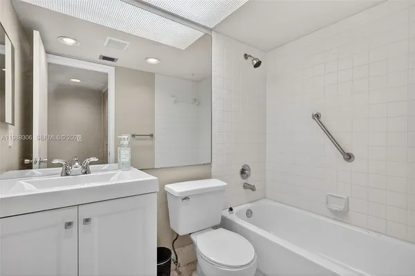 a bathroom with a sink a toilet a mirror and shower