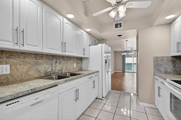 a kitchen with a sink dishwasher a refrigerator and cabinets