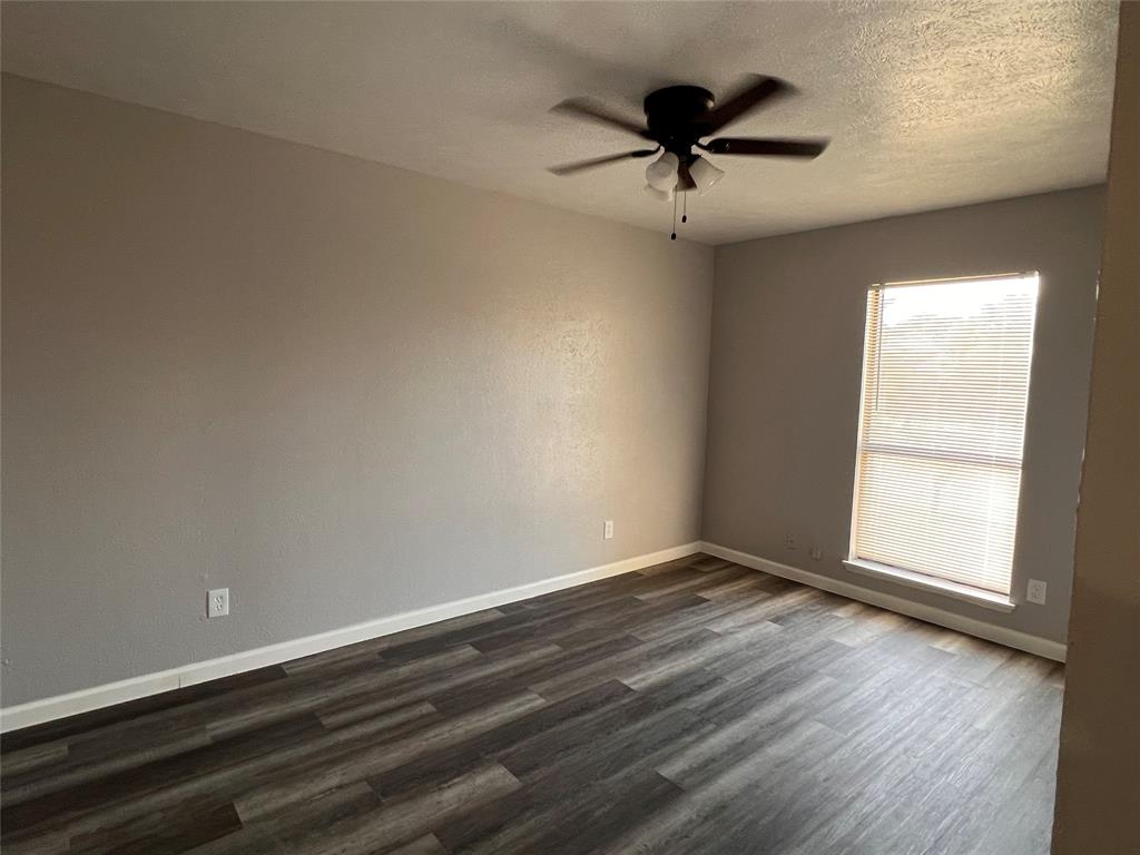 8506 Woodside Road Rowlett, TX 75088 - Photo 19 of 27 an empty room with wooden floor and ceiling fan