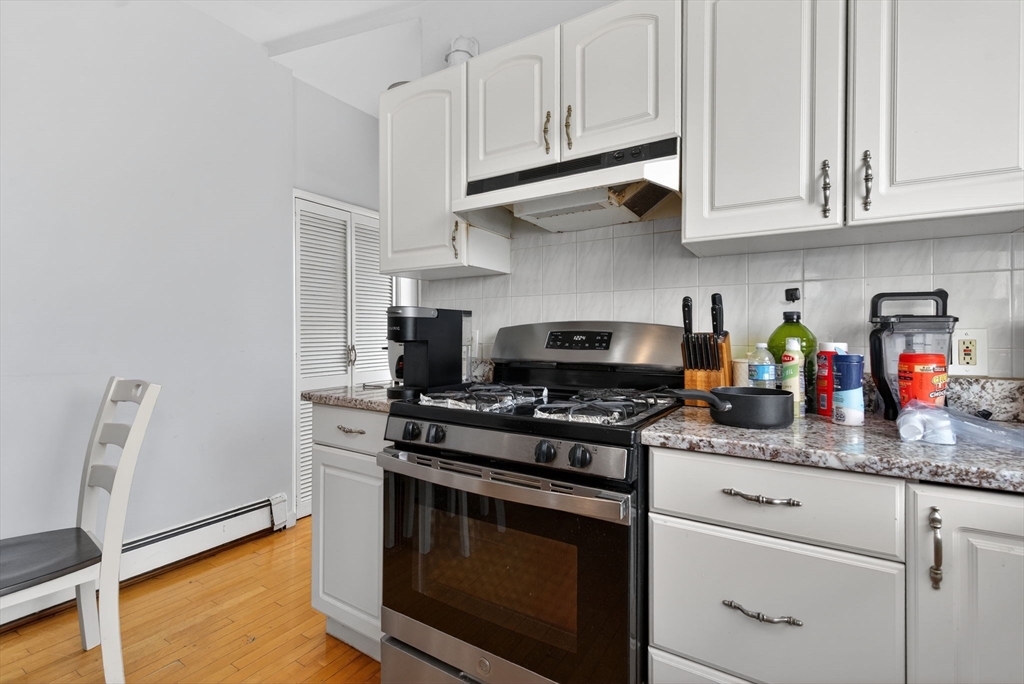 1748 North Shore Road Revere, MA 02151 - Photo 2 of 20 a kitchen with stainless steel appliances granite countertop white cabinets and a stove top oven