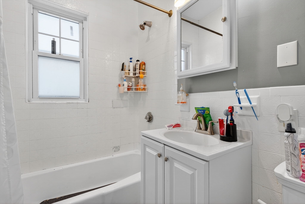 1748 North Shore Road Revere, MA 02151 - Photo 9 of 20 a bathroom with a bathtub sink and cabinets