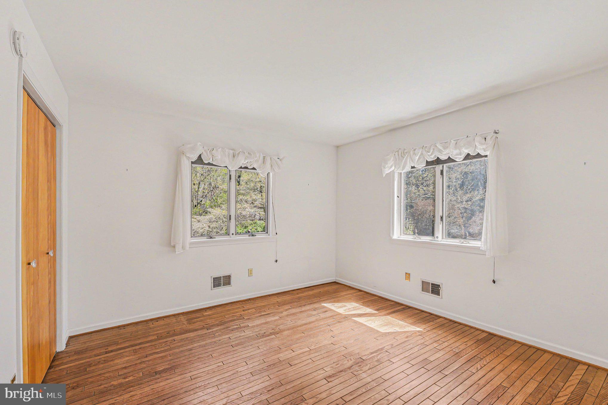 13800 Cripplegate Road Phoenix, MD 21131 - Photo 11 of 47 an empty room with wooden floor and windows