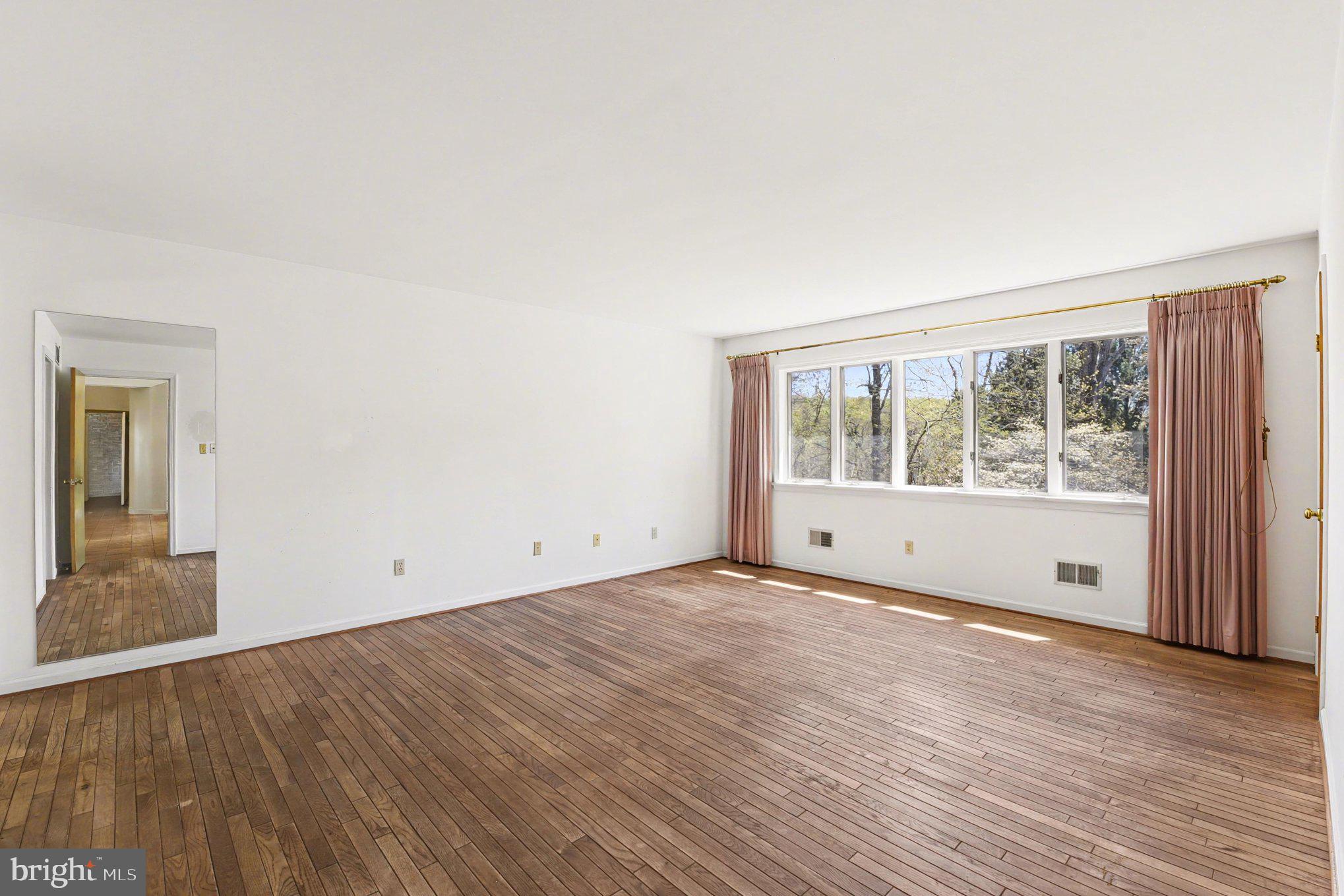 13800 Cripplegate Road Phoenix, MD 21131 - Photo 9 of 47 an empty room with wooden floor and windows