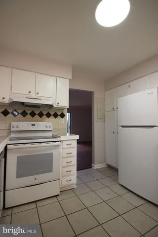 a kitchen with cabinets and white appliances