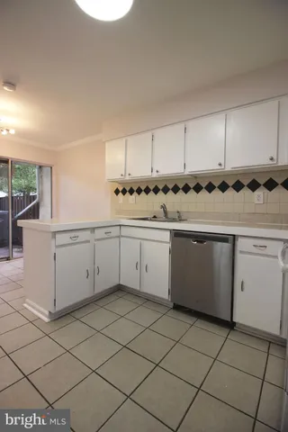 a kitchen with a sink a stove cabinets and counter space