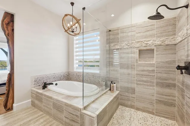 a bathroom with a tub a sink and a shower