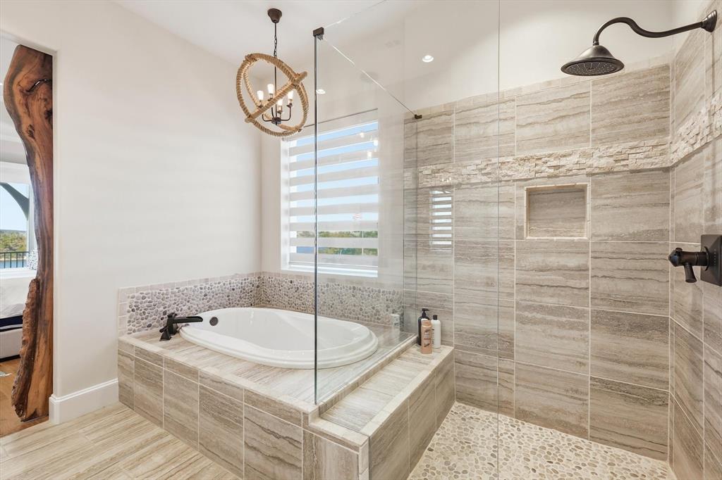 7105 West Hells Gate Drive Strawn, TX 76475 - Photo 14 of 39 a bathroom with a tub a sink and a shower