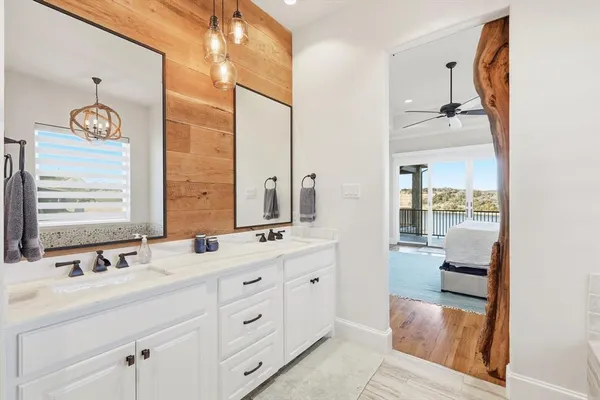 a bathroom with a double vanity sink a mirror and a shower