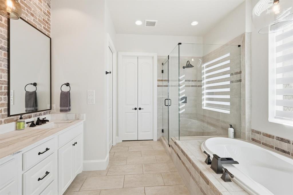7105 West Hells Gate Drive Strawn, TX 76475 - Photo 18 of 39 a bathroom with a double vanity sink mirror double and bathtub