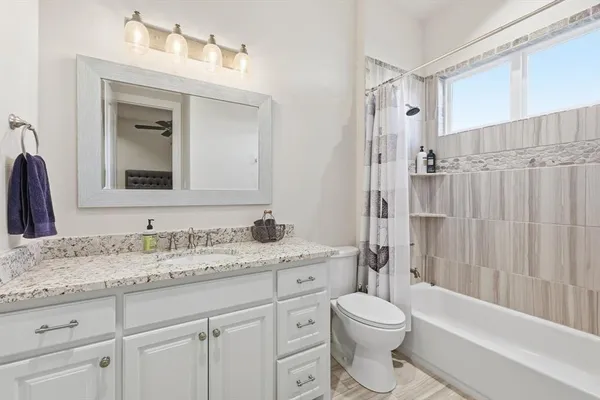 a bathroom with a granite countertop sink toilet and shower