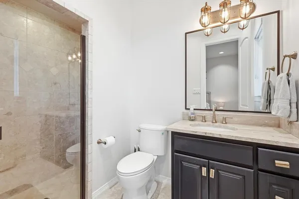 a bathroom with a sink vanity granite and toilet