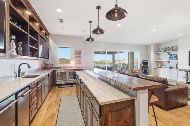 a large kitchen with stainless steel appliances granite countertop a stove and cabinets