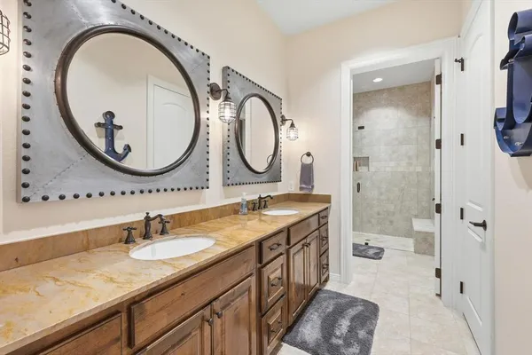 a bathroom with a granite countertop double vanity sink and a mirror