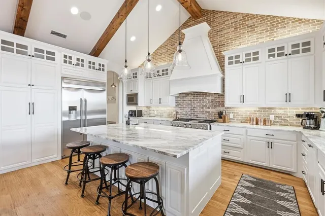 a kitchen with stainless steel appliances kitchen island granite countertop a sink and cabinets