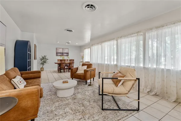 a living room with furniture a rug and a floor to ceiling window