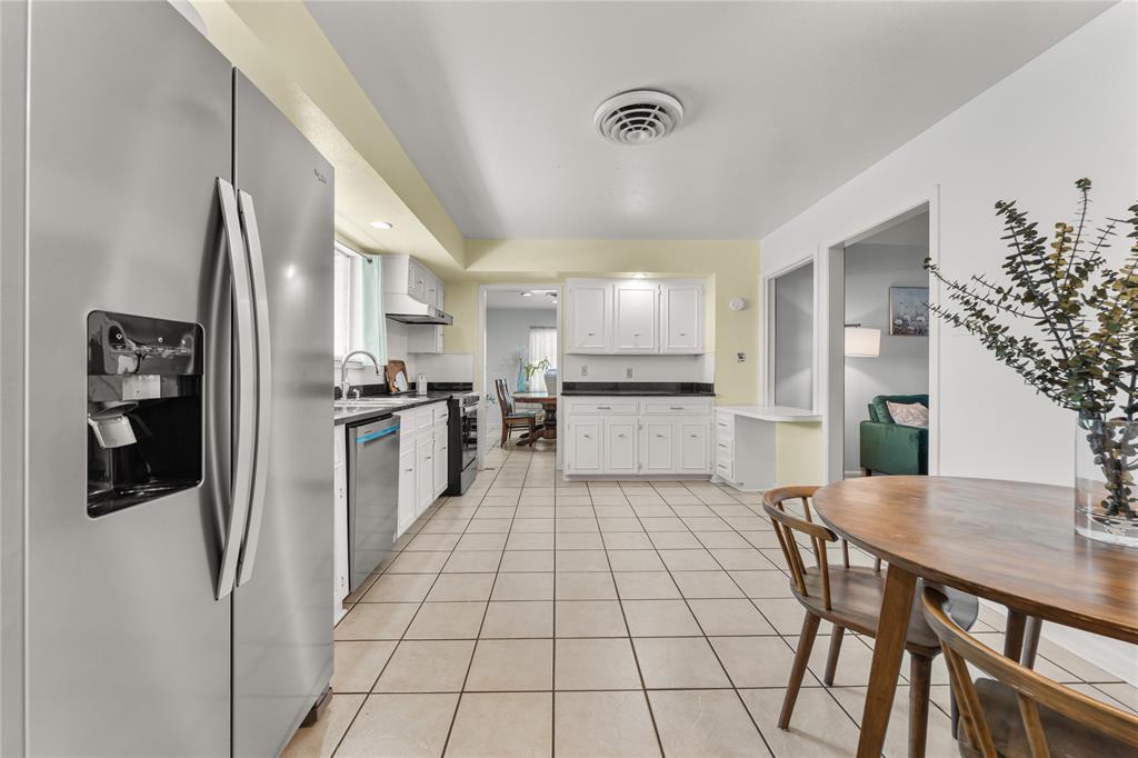2612 Glendale Drive Waco, TX 76708 - Photo 6 of 38 Kitchen featuring stainless steel appliances, light tile patterned floors, white cabinetry, and dark countertops