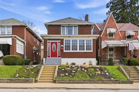 a front view of a house with lots of trees