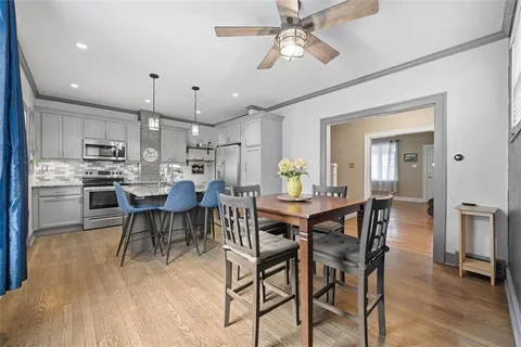 a kitchen with stainless steel appliances granite countertop a stove a sink dishwasher a refrigerator with a dining table and chairs