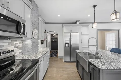 a kitchen with a refrigerator a sink and chairs