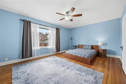 a bedroom with bed and wooden floor