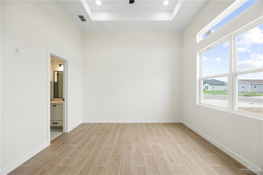 3610 Satelite Street Edinburg, TX 78542 - Photo 8 of 22 an empty room with a window and wooden floor