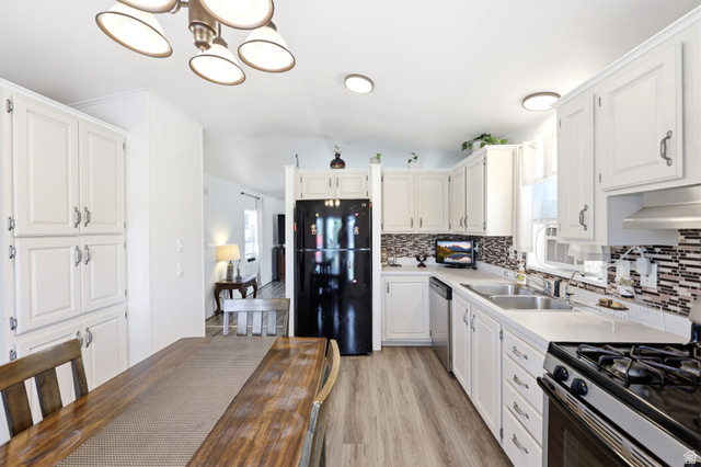 1525 South 400 East, Unit 13 Springville, UT 84663 - Photo 15 of 32 Bright kitchen featuring wood-finish flooring, white cabinetry, a dual basin sink, a mosaic tile backsplash, and a black appliance suite