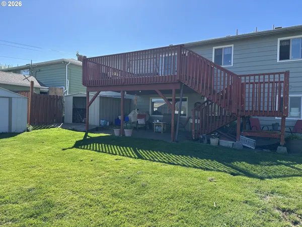 a view of a chair and table in backyard of the house