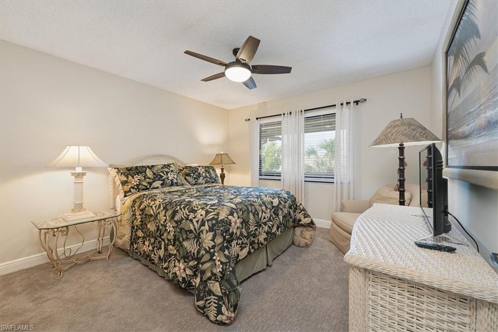 75 St Andrews Boulevard, Unit C301 Naples, FL 34113 - Photo 19 of 41 a bedroom with a bed and a table