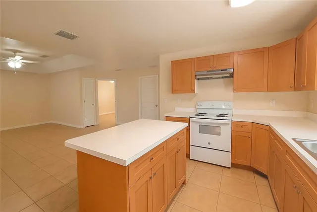 a kitchen with a stove cabinets and wooden floor