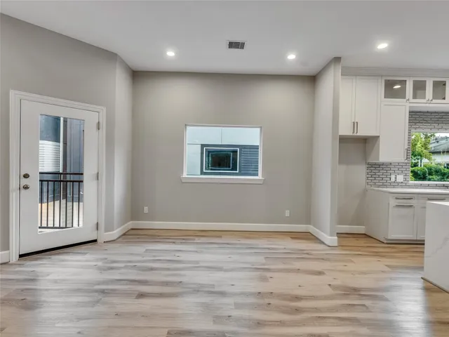 an empty room with wooden floor and entrance