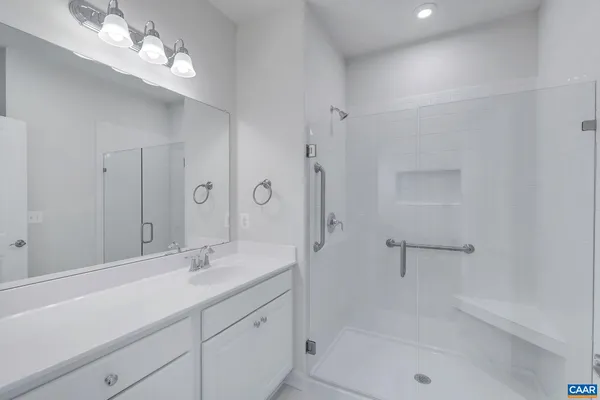 a bathroom with a shower sink large mirror and vanity