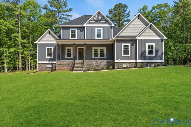 a front view of a house with a yard and green space